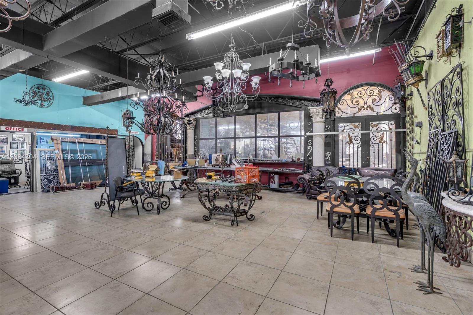 A showroom displays various wrought iron chandeliers, furniture, and decorative metalwork on tiled floors — 341 W 21st St, Hialeah FL 33010, HIALEAH, FL