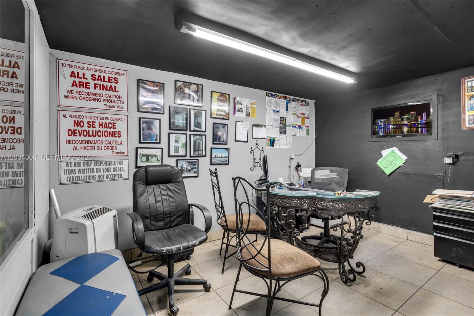 An office space features a glass-topped desk, chairs, wall-mounted signs, and a black ceiling — 341 W 21st St, Hialeah FL 33010, HIALEAH, FL