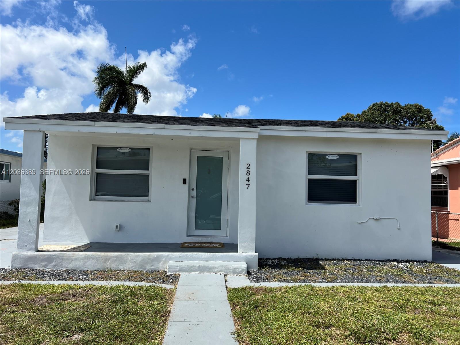 A single-story white house with a front porch, two windows, and a central glass door — 2847 Polk St # 1, Hollywood FL 33020, HOLLYWOOD, FL