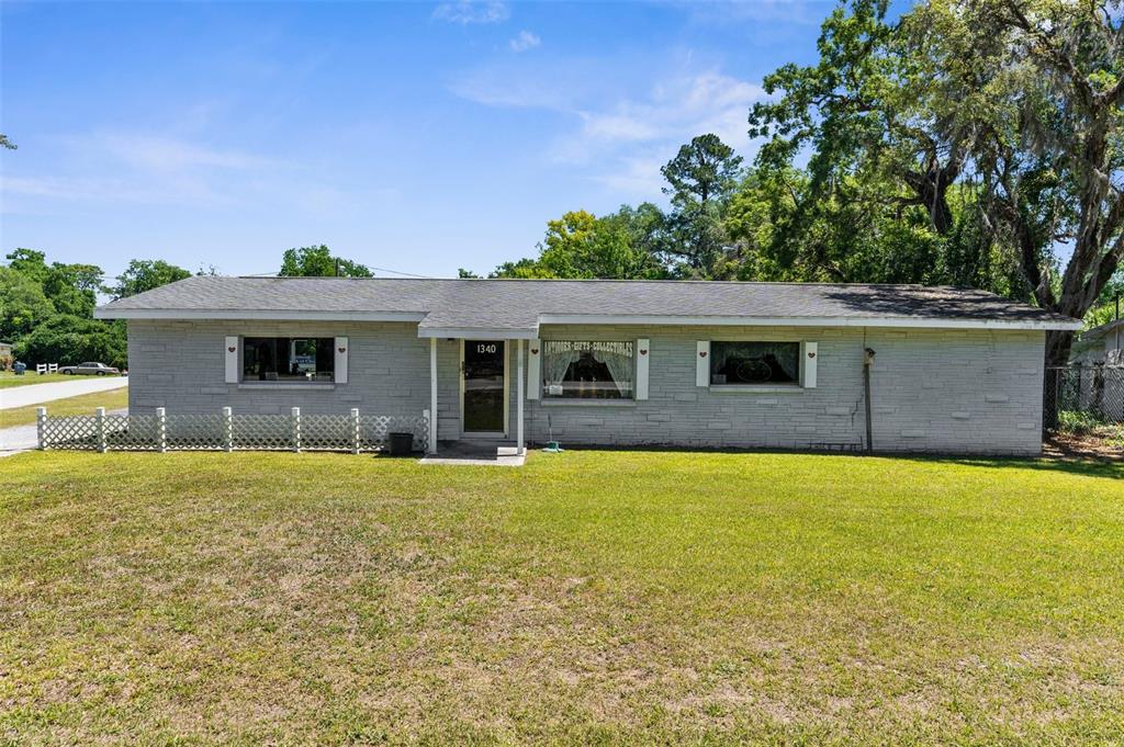 A single-story gray brick building with a front entrance and a large grassy yard — 1340 HOWELL AVENUE, BROOKSVILLE, FL