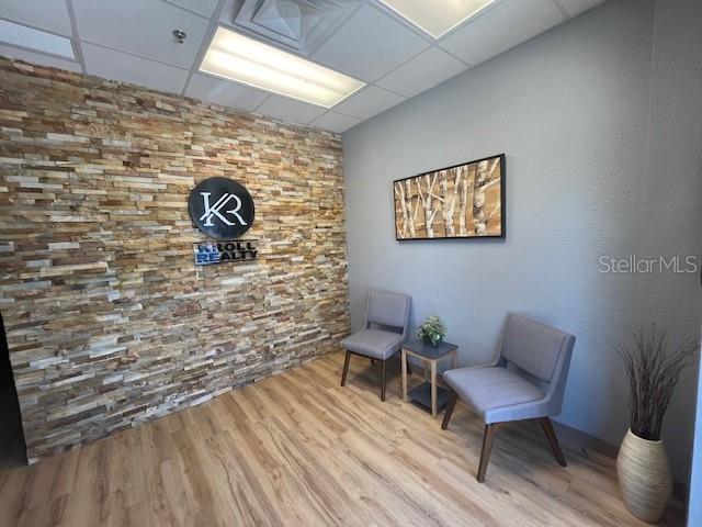 A waiting area features a stone accent wall, two gray chairs, and light wood flooring — 4031 W STATE ROAD 46 UNIT C, SANFORD, FL