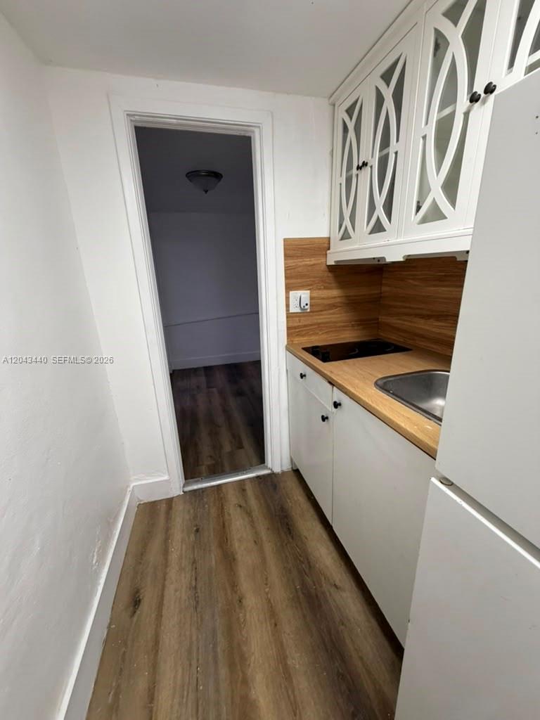 A small kitchenette features white cabinets, a wood-look countertop, and a doorway leading inside — 2137 NW 1st Ter, Miami FL 33125, MIAMI, FL