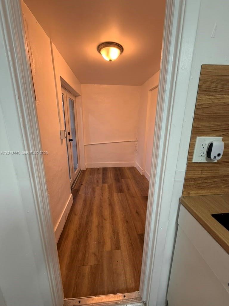 A narrow room with wood-look flooring, white walls, a ceiling light, and glass doors — 2137 NW 1st Ter, Miami FL 33125, MIAMI, FL