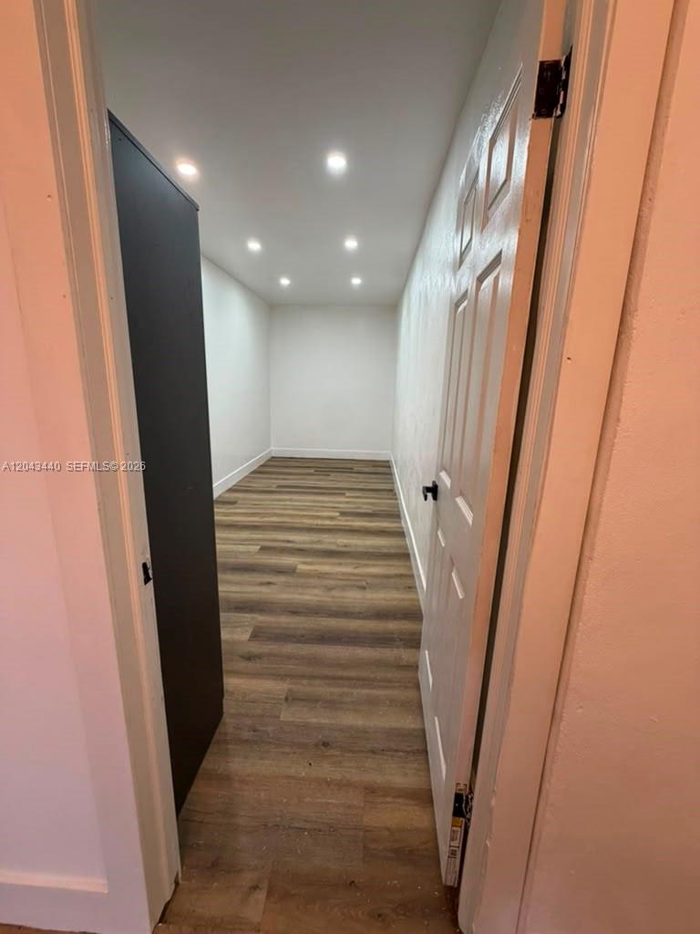 A narrow, empty room features wood-look flooring, white walls, and recessed ceiling lighting — 2137 NW 1st Ter, Miami FL 33125, MIAMI, FL
