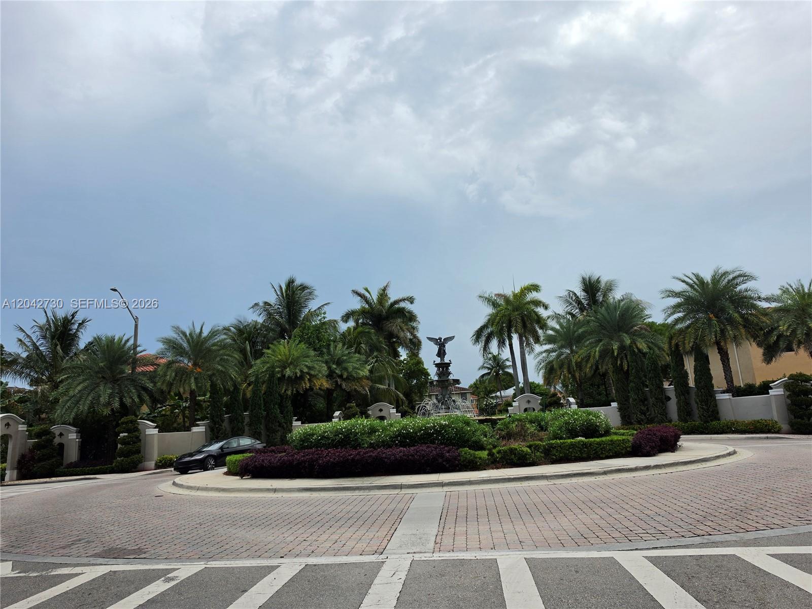 A roundabout features a central fountain with a statue surrounded by palm trees and landscaping — 4906 SW 141st Ave # 4, Miramar FL 33027, MIRAMAR, FL