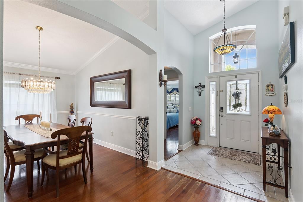 A kitchen with white cabinets, a wooden island, tile floors, and an adjacent dining area — 9943 HERON POINTE DRIVE, ORLANDO, FL