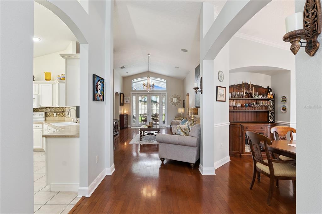 A screened-in patio features a dining set under a teal umbrella on a tiled floor — 9943 HERON POINTE DRIVE, ORLANDO, FL