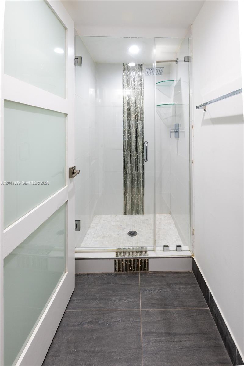 A walk-in shower with a glass door and a decorative mosaic tile accent wall — 4538 SW 1st St # 3, Miami FL 33134, MIAMI, FL