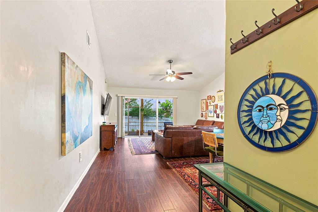 A living room with wood flooring, a ceiling fan, and a glass sliding door — 1356 LANDRY CIRCLE, LONGWOOD, FL