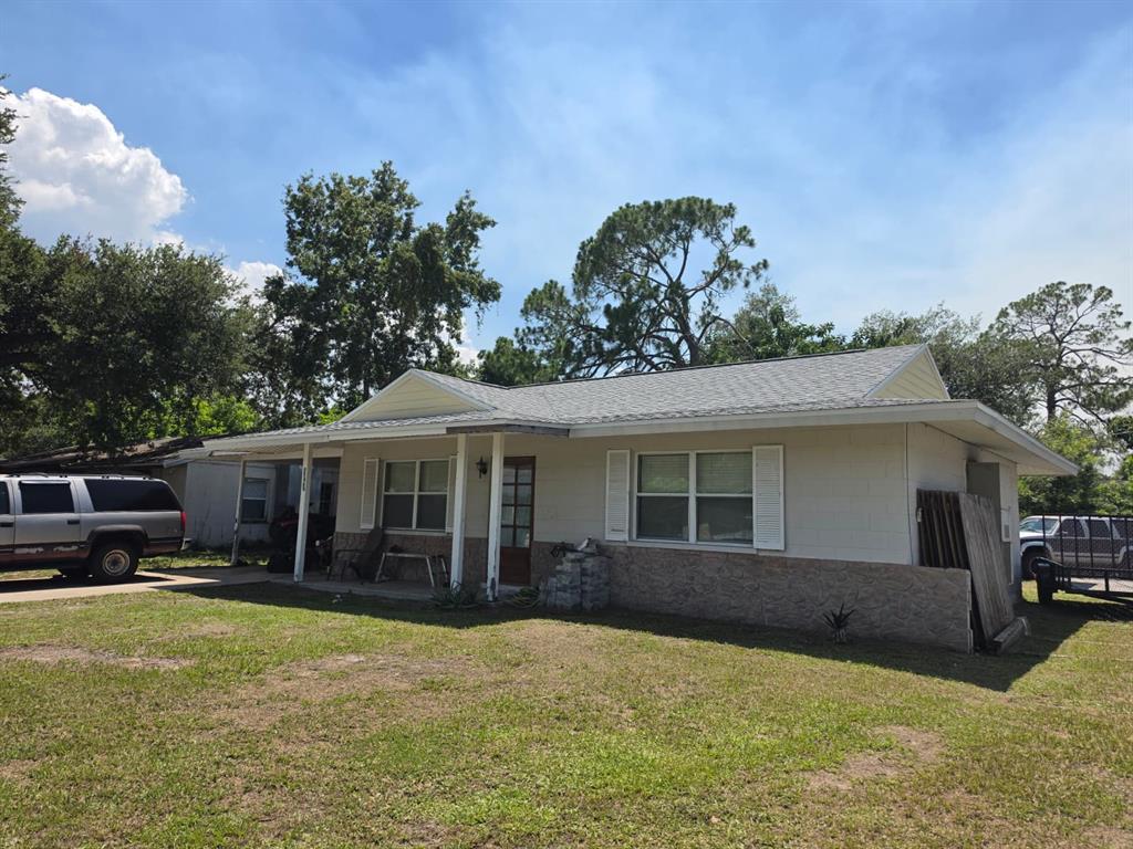 A single-story house with a light-colored exterior, a covered porch, and a gray shingled roof — 3940 BERKSHIRE DRIVE, SARASOTA, FL