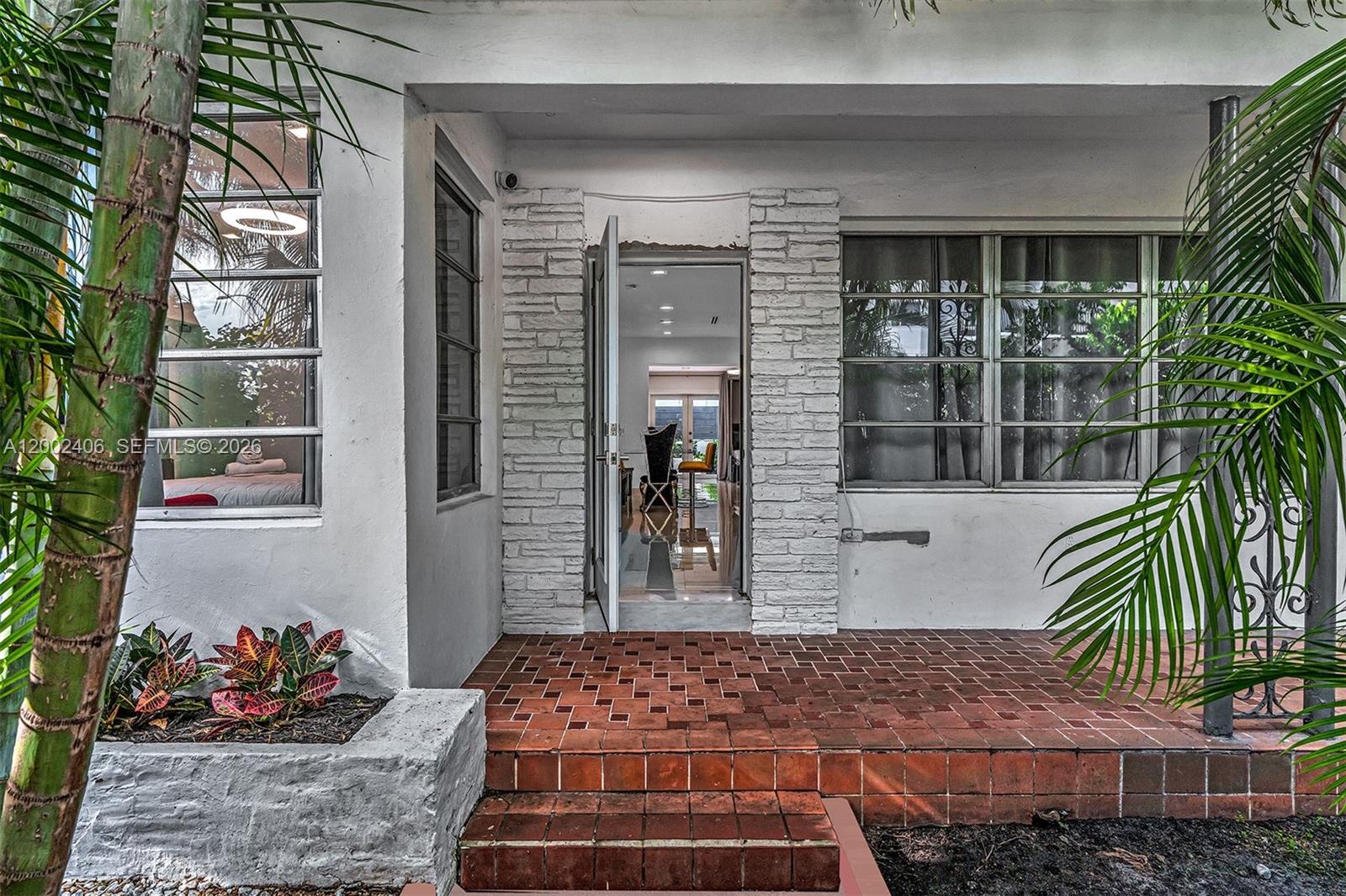 A white house exterior features a brick porch, stone-textured door frame, and large windows — 1002 10th St # 1002, Miami Beach FL 33139, MIAMI BEACH, FL