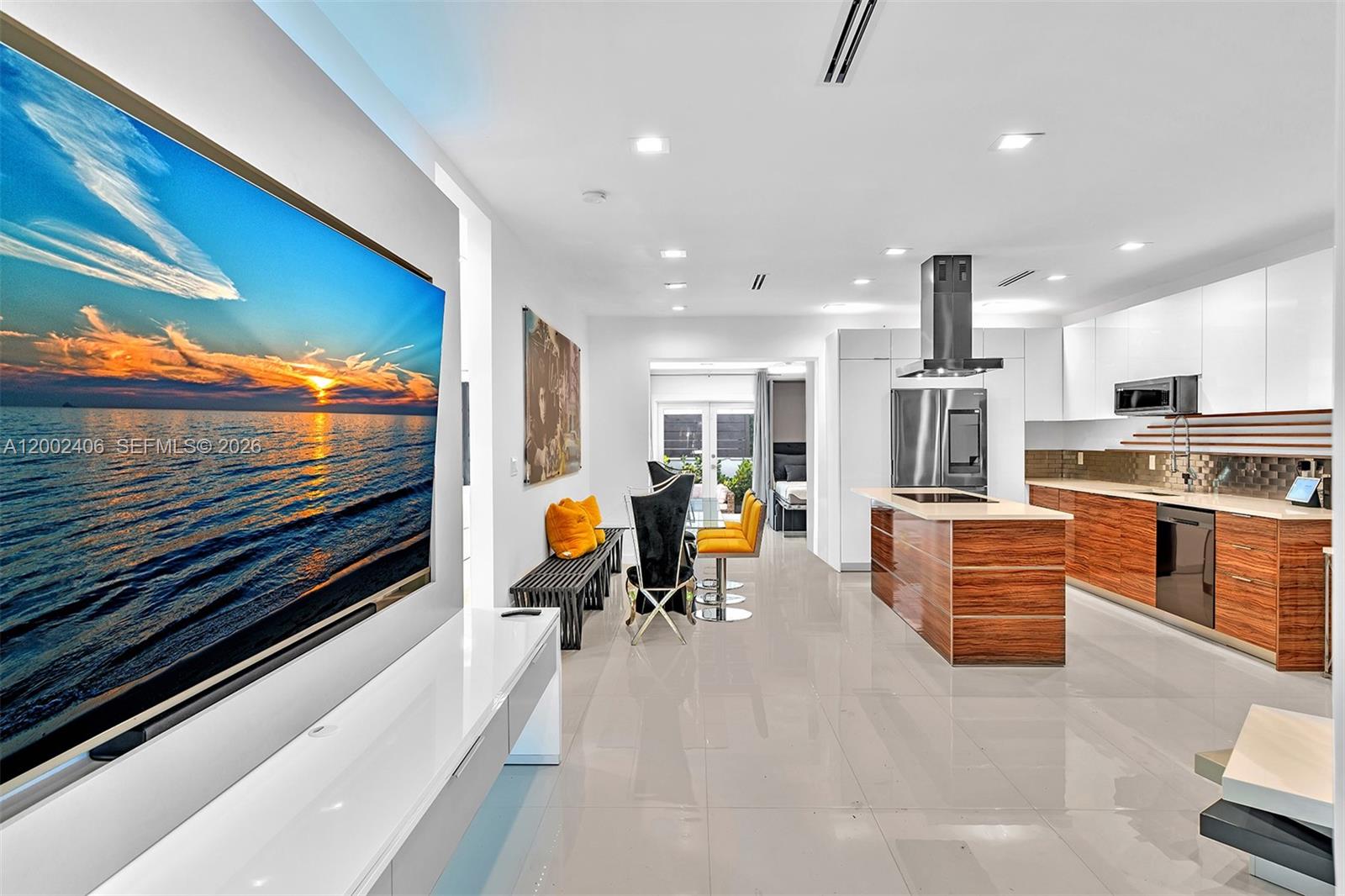 A modern open-concept kitchen and living area features wood cabinetry, white countertops, and tile flooring — 1002 10th St # 1002, Miami Beach FL 33139, MIAMI BEACH, FL