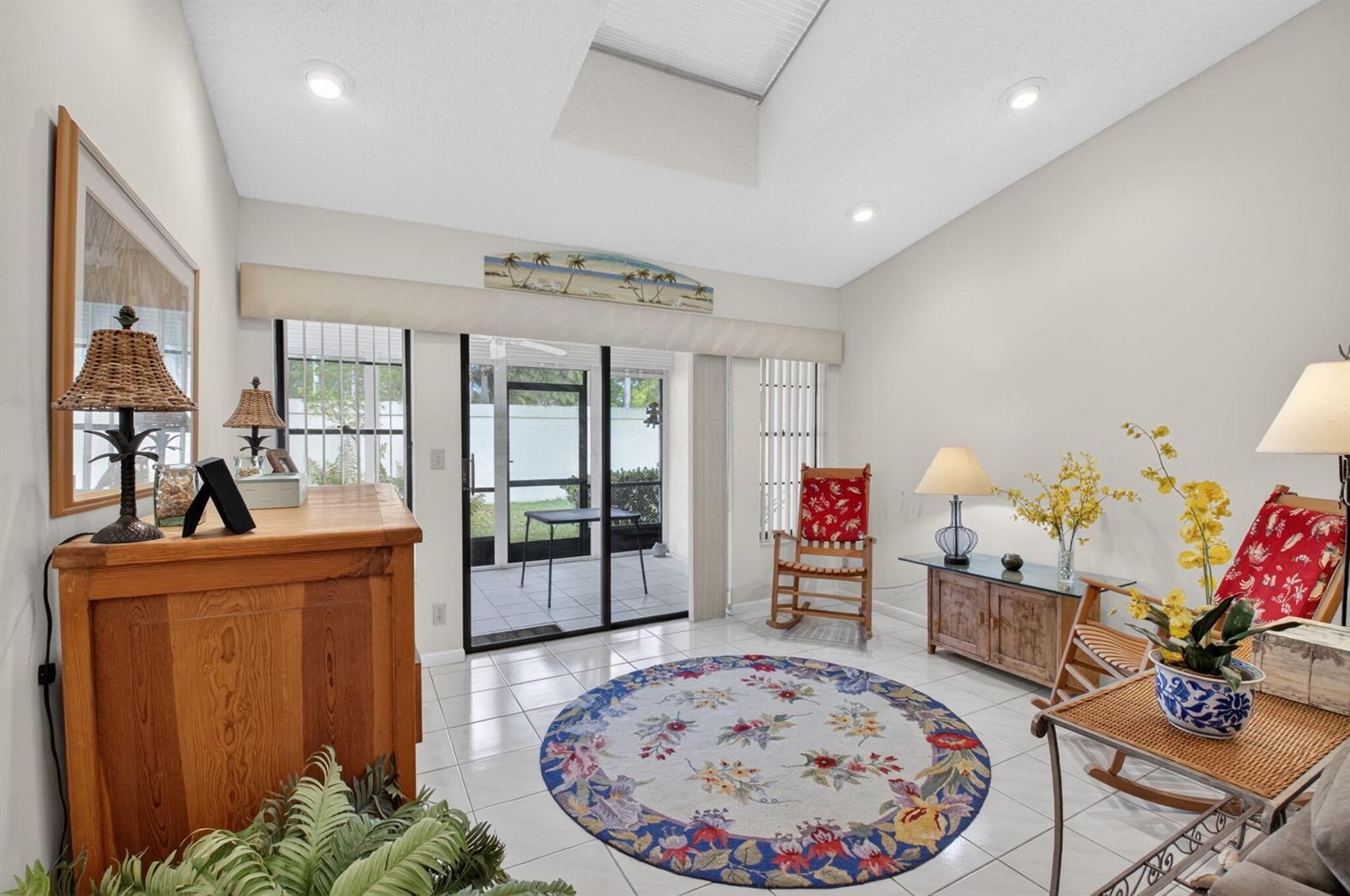 A sunlit living room features tile flooring, a skylight, and sliding glass doors to a patio — 10039 Andrea Lane # A, Boynton Beach FL 33437, BOYNTON BEACH, FL