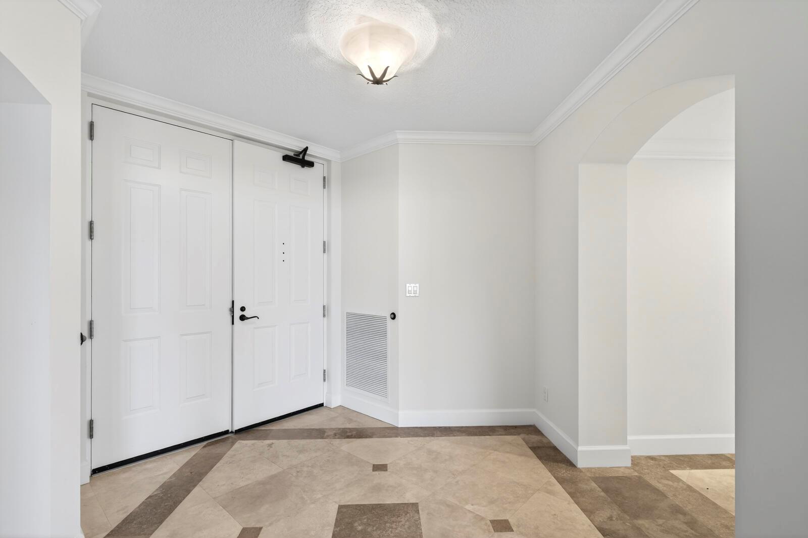An entryway features white double doors, a tiled floor, and an arched doorway — FORT PIERCE, FL