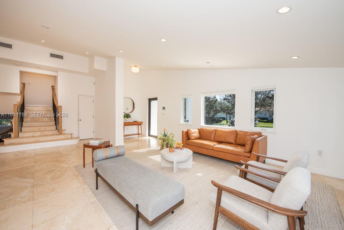A living room features a tan leather sofa, two armchairs, a gray daybed, and stairs — 717 Benevento Ave, Coral Gables FL 33146, CORAL GABLES, FL