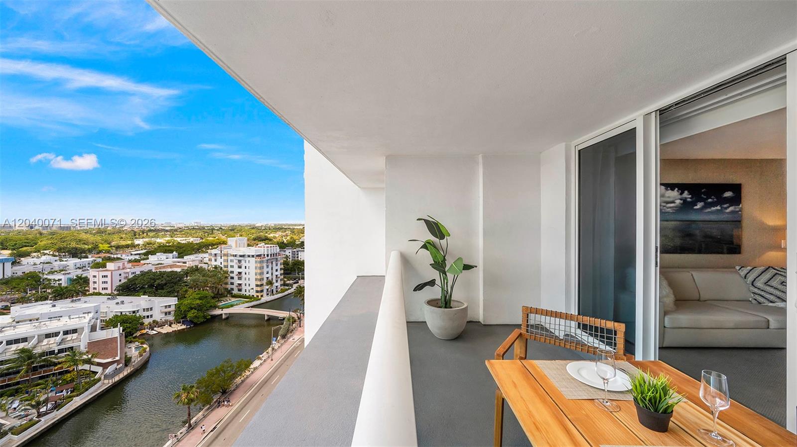 A balcony with a table and chairs overlooks a canal and city buildings — 102 24 # 1545, Miami Beach FL 33139, MIAMI BEACH, FL