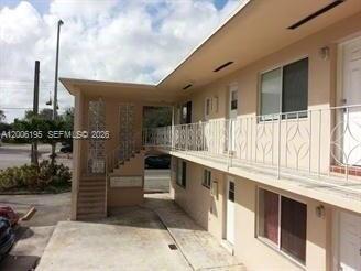 A two-story apartment building exterior features a concrete staircase, metal railings, and a parking area — 14305 NE 6th Ave, North Miami FL 33161, NORTH MIAMI, FL