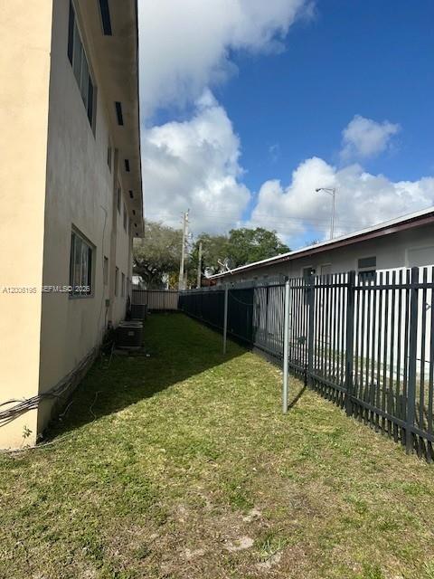 A narrow grassy side yard sits between a beige building and a black metal fence — 14305 NE 6th Ave, North Miami FL 33161, NORTH MIAMI, FL