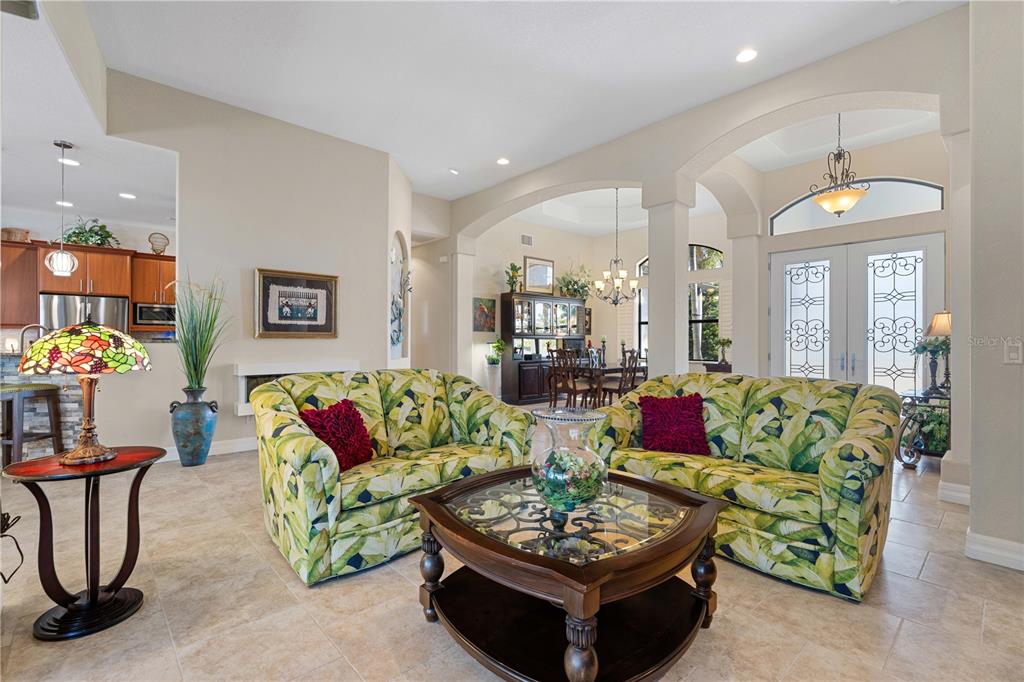 A living room features two tropical-print sofas, a glass-topped coffee table, and tiled flooring — 3615 TOWHEE COURT, PUNTA GORDA, FL