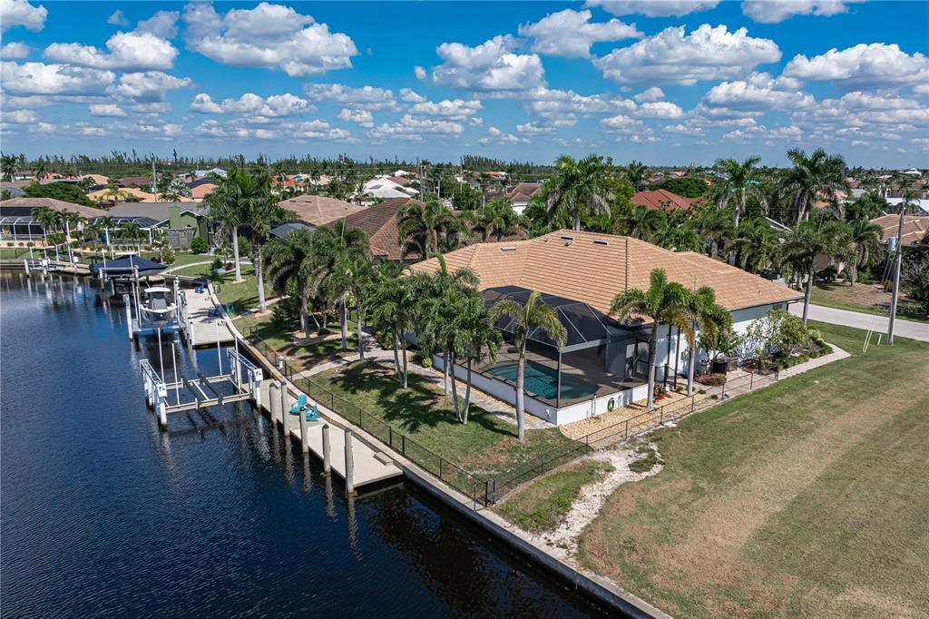 An aerial view of a waterfront house with a pool, screened lanai, and private dock — 3615 TOWHEE COURT, PUNTA GORDA, FL