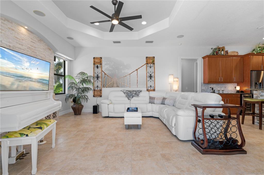 A living room features a white sectional sofa, a white piano, and a ceiling fan — 3615 TOWHEE COURT, PUNTA GORDA, FL