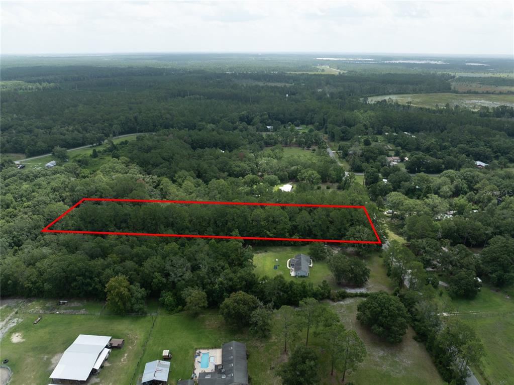 An aerial view shows a rectangular plot of land outlined in red amidst dense forest — 0 SE 144TH STREET, STARKE, FL