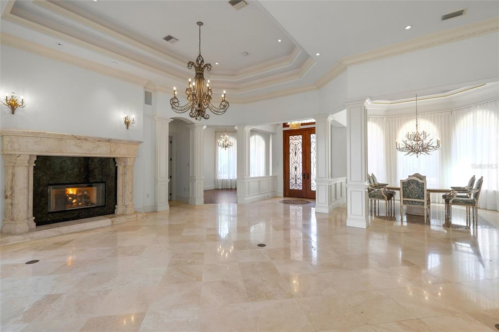 A spacious living area features a stone fireplace, tile flooring, and a formal dining space — 6702 CHANCERY PLACE, UNIVERSITY PARK, FL