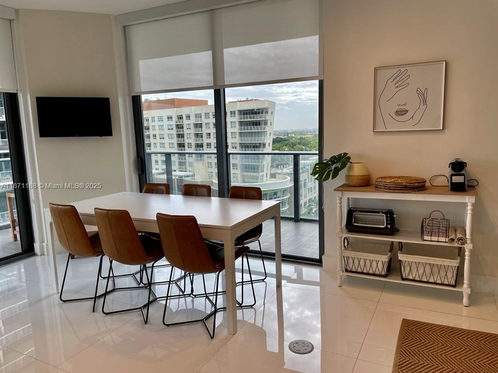 A dining area features a white table, brown chairs, and a console table near windows — 121 NE 34 ST # 901, Miami FL 33137, MIAMI, FL