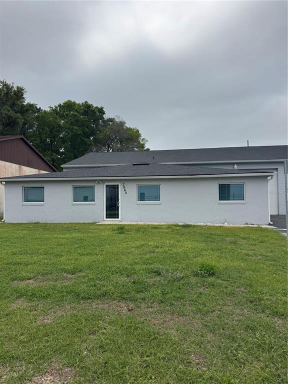 A single-story gray building with a dark shingled roof and a central glass door — 3660 NE 42ND LANE, OCALA, FL