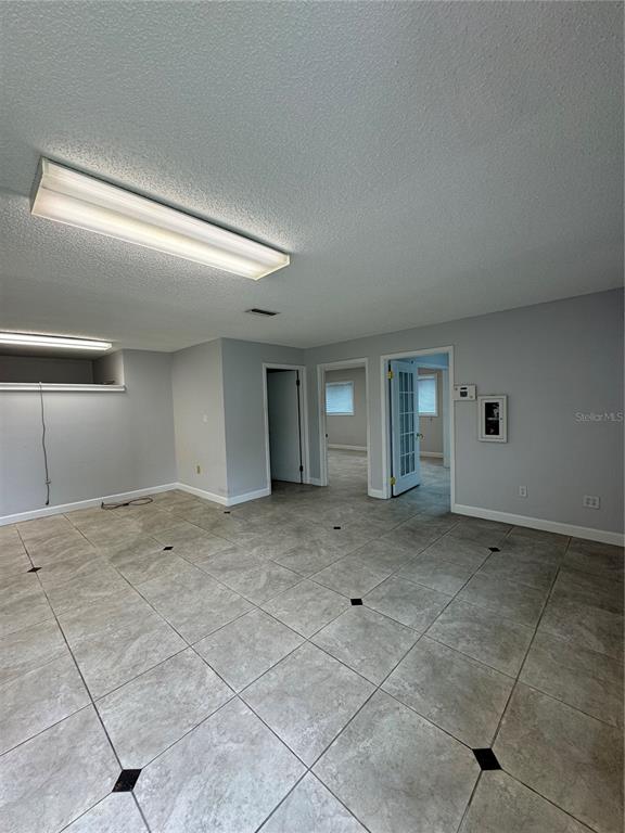 A room with light gray walls, tile flooring, and two doorways leading to other rooms — 3660 NE 42ND LANE, OCALA, FL