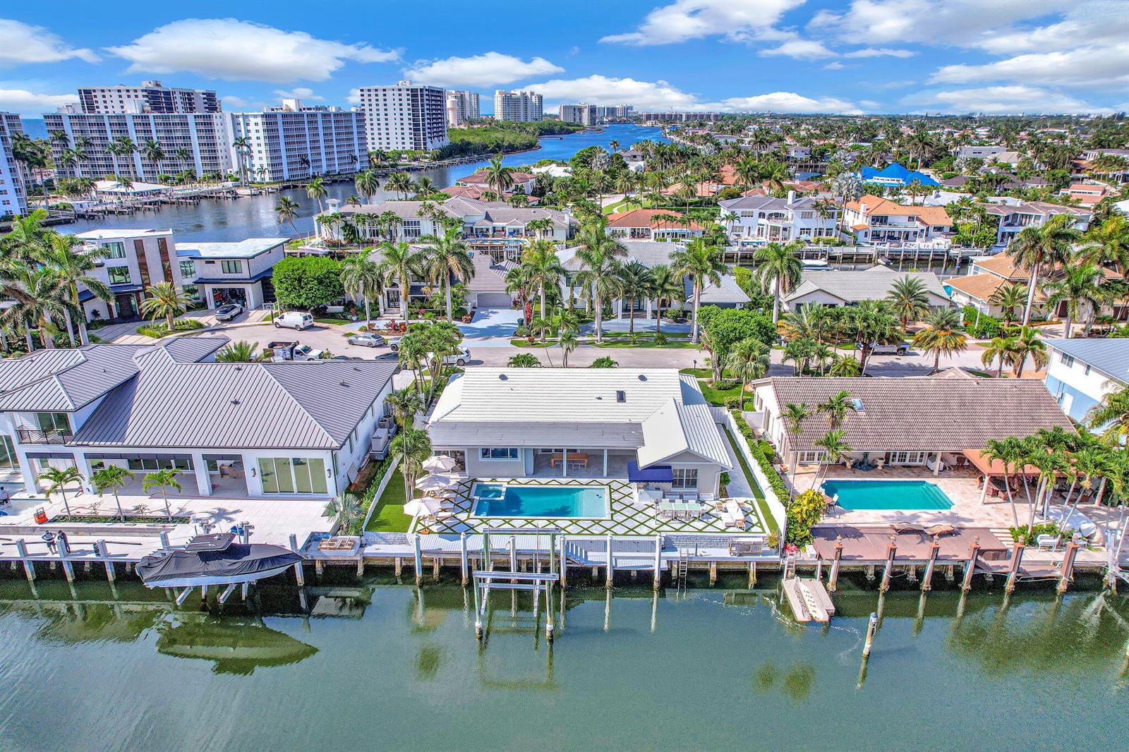 An aerial view of three waterfront houses with pools and private docks along a canal — 885 Nafa Drive, Boca Raton FL 33487, BOCA RATON, FL