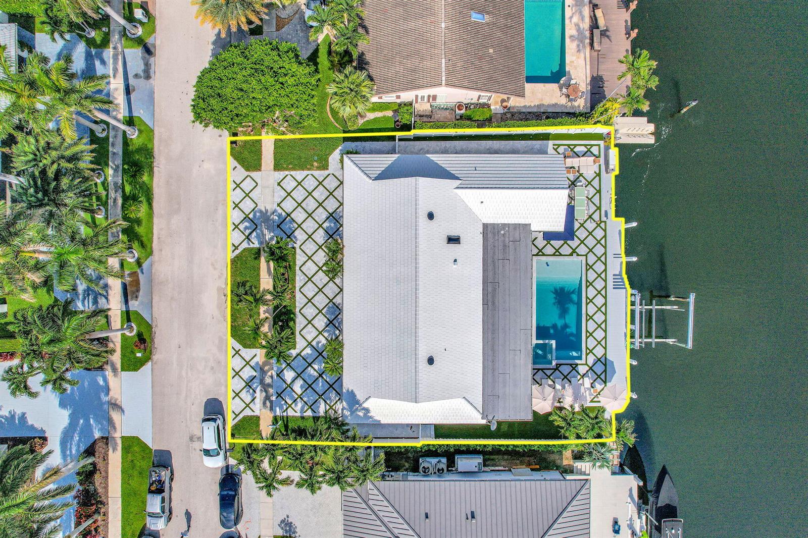 An aerial view shows a waterfront house with a pool, patio, and landscaped yard — 885 Nafa Drive, Boca Raton FL 33487, BOCA RATON, FL