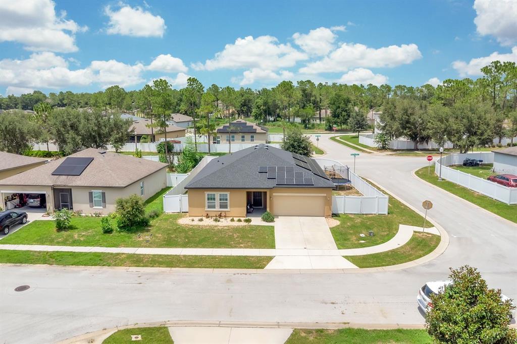 An aerial view shows a tan single-story house with a dark roof and solar panels — 996 JOYCE ROAD, LAKE WALES, FL