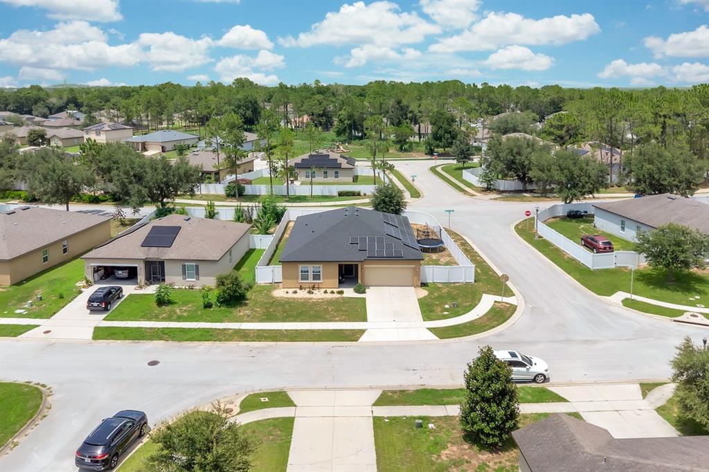An aerial view shows suburban houses with solar panels on a sunny day — 996 JOYCE ROAD, LAKE WALES, FL