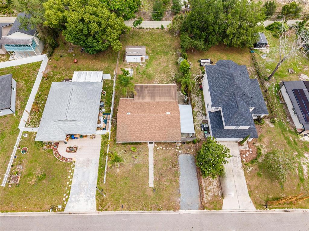 An aerial view shows three residential houses with driveways and yards along a paved street — 251 PINE TREE DRIVE, CASSELBERRY, FL