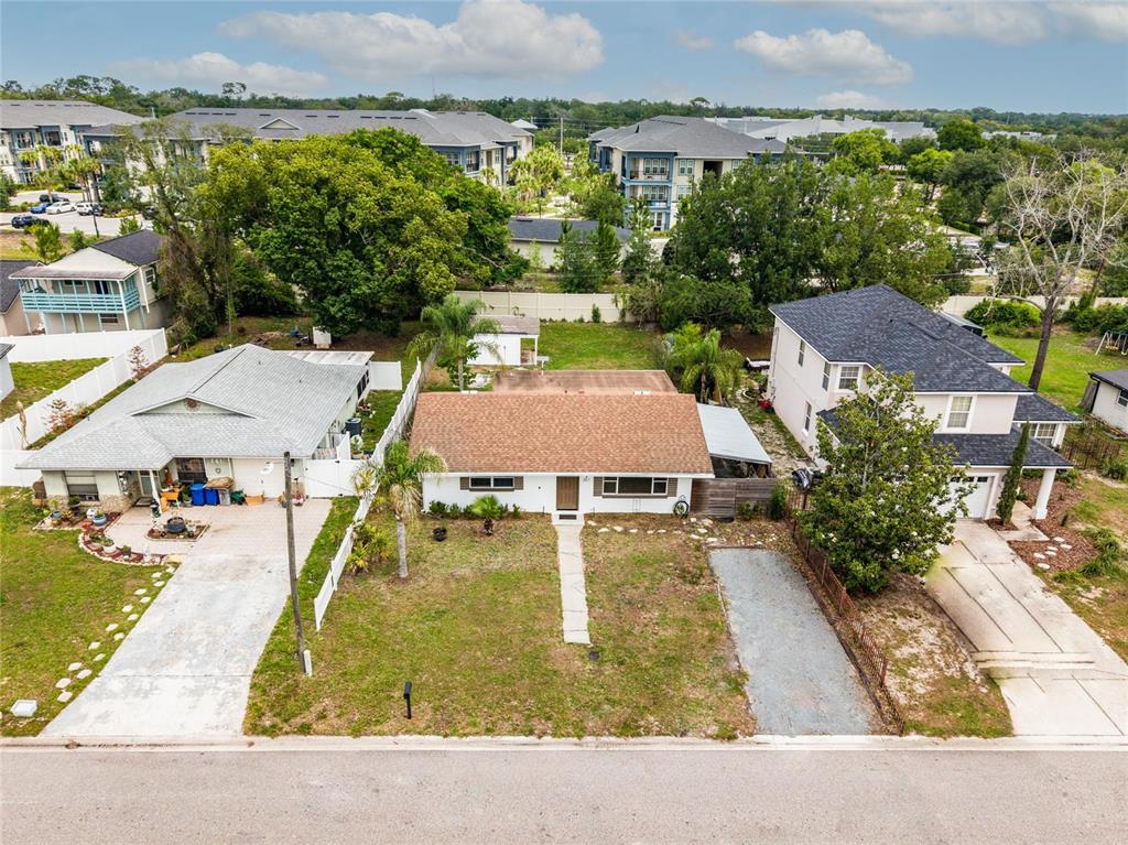 An aerial view shows a single-story house with a brown roof between two neighboring homes — 251 PINE TREE DRIVE, CASSELBERRY, FL