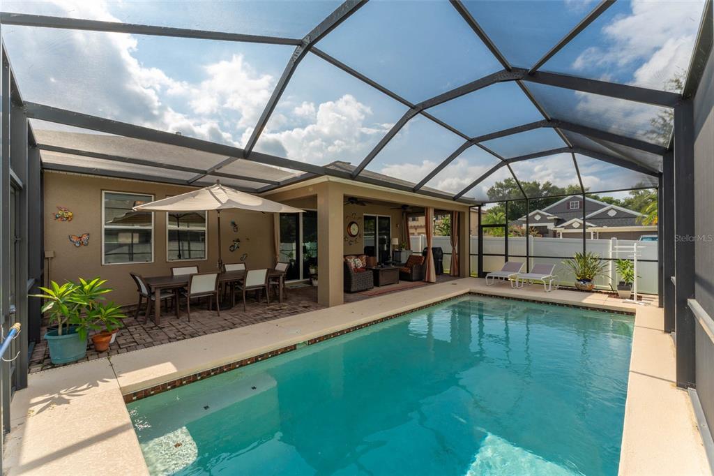 A screened-in patio features a swimming pool, outdoor dining area, and lounge chairs — 220 PARSONS WOODS DRIVE, SEFFNER, FL