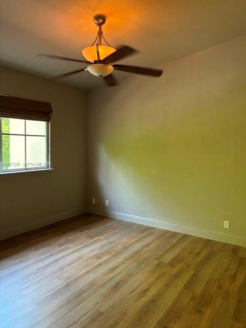 An empty room features wood-look flooring, a ceiling fan with lights, and a window — 2551 SW 99th Way, Miramar FL 33025, MIRAMAR, FL