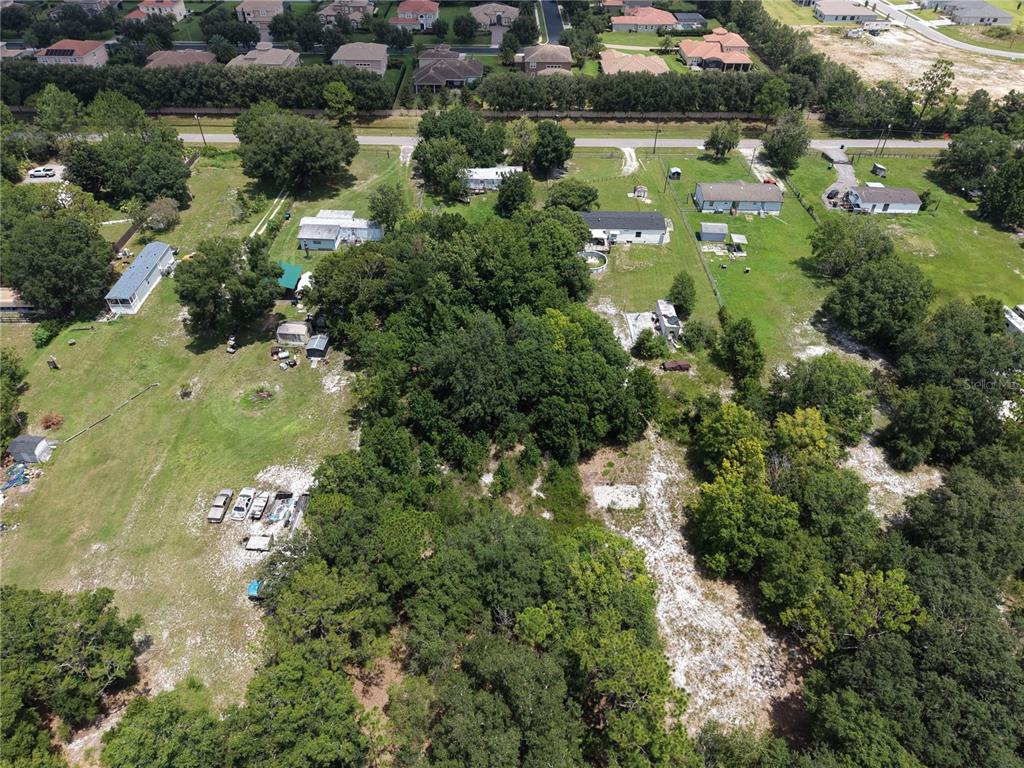 An aerial view shows a rural property with several mobile homes and scattered trees — 18440 AMITYVILLE DR, ORLANDO, FL