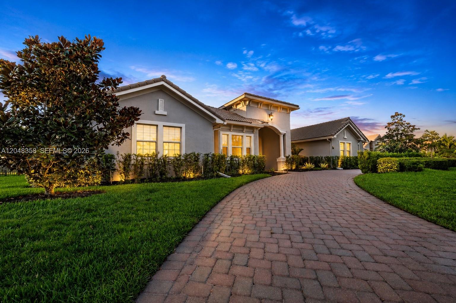 A paved driveway leads to the front entrance of a single-story gray stucco house — 5301 S Sterling Ranch Cir, Davie FL 33314, DAVIE, FL