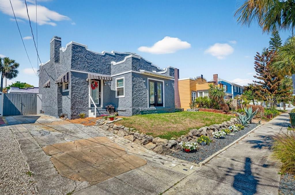 A gray stucco house with a flat roof and a front lawn with rock landscaping — 112 S OLEANDER AVENUE, DAYTONA BEACH, FL