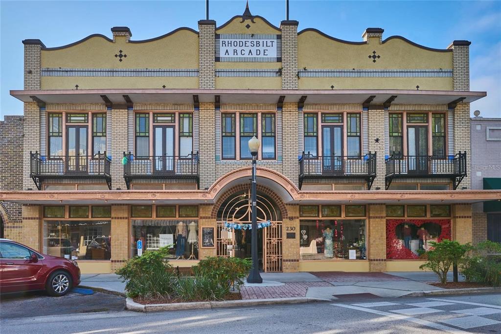 The exterior of the two-story brick Rhodesbilt Arcade building features a central arched entrance — 230 E PARK AVENUE, LAKE WALES, FL
