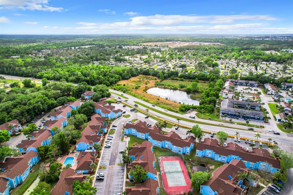 Aerial view of a residential apartment complex with a tennis court and swimming pool — 2731 N POINCIANA BOULEVARD UNIT 114, KISSIMMEE, FL