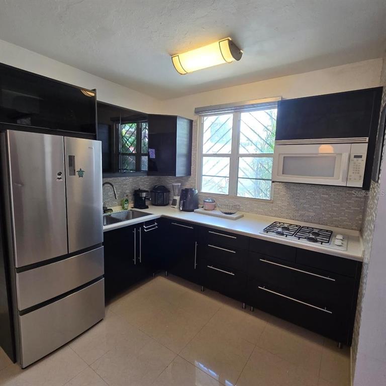 A modern kitchen features dark cabinetry, stainless steel appliances, and a light-colored countertop — Doncella PLAZA COND UNIT 2, SAN JUAN, PR