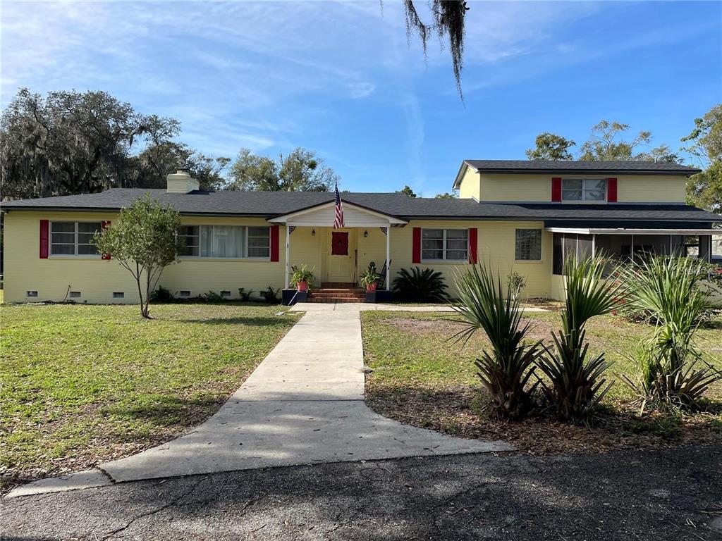A yellow single-story house with a dark roof, red shutters, and a central front porch — 750 CHARLIE TAYLOR ROAD, PLANT CITY, FL