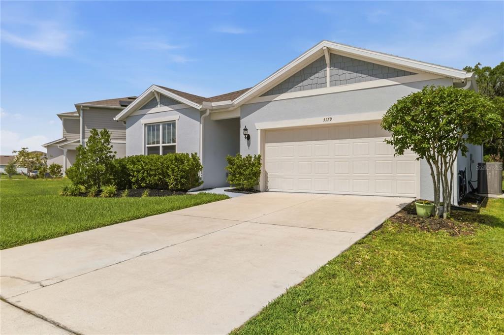 A light blue single-story house with a two-car garage and a concrete driveway — 5179 ROYAL POINT AVENUE, KISSIMMEE, FL