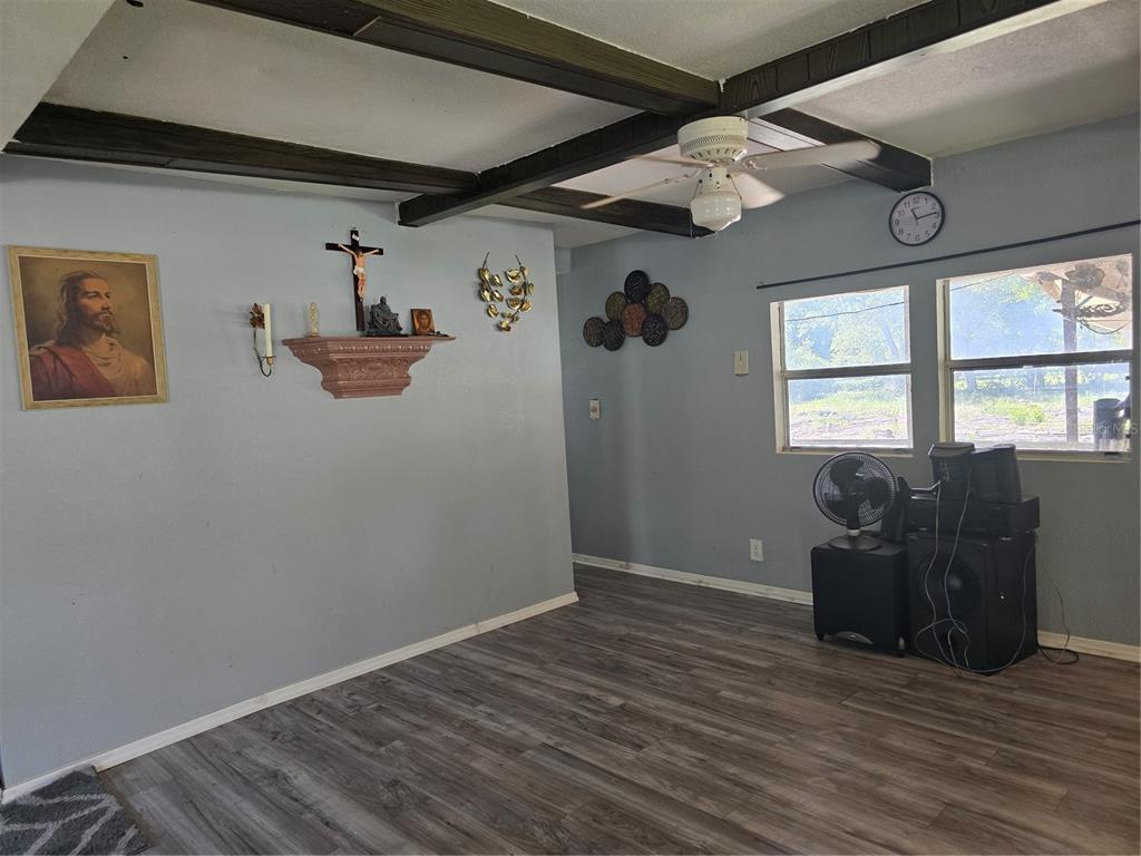 A living room features a brown leather sofa and loveseat on a patterned gray rug — 5302 SWAYING PALM DRIVE, PUNTA GORDA, FL
