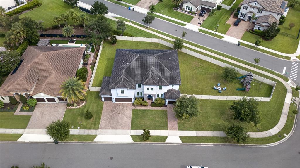An aerial view shows a two-story house with a dark roof and a large backyard — 659 RED HAVEN LANE, OVIEDO, FL