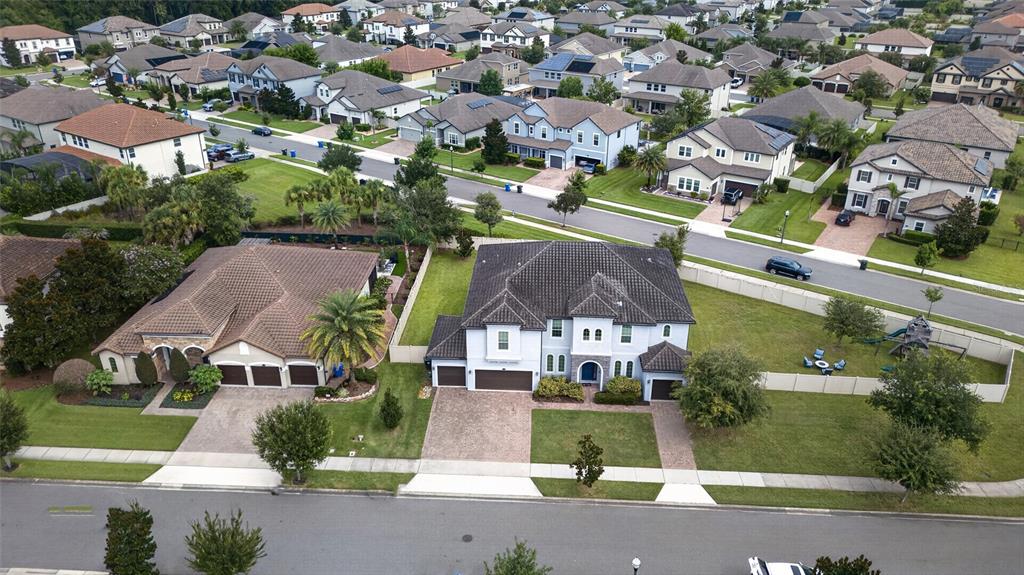 An aerial view shows two large suburban houses with tiled roofs and paved driveways — 659 RED HAVEN LANE, OVIEDO, FL