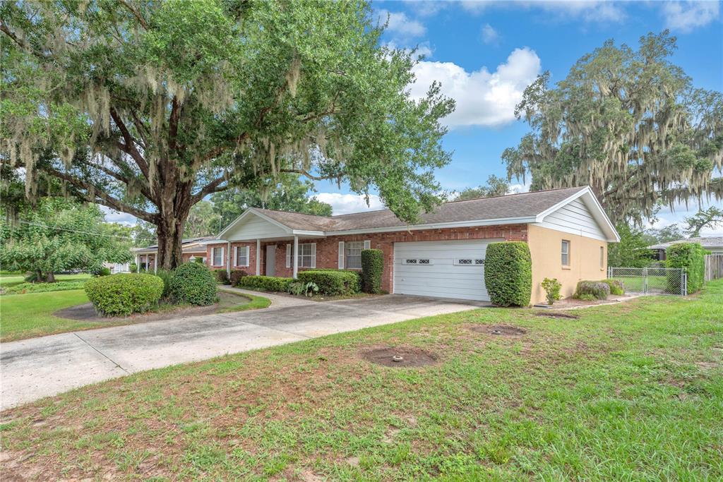 A single-story brick house with a two-car garage and a large oak tree in front — 110 ASHBROOK DRIVE, BRANDON, FL
